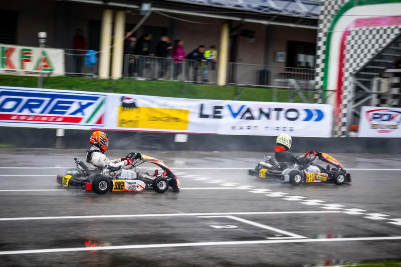 Karts crossing the finish line on a wet track